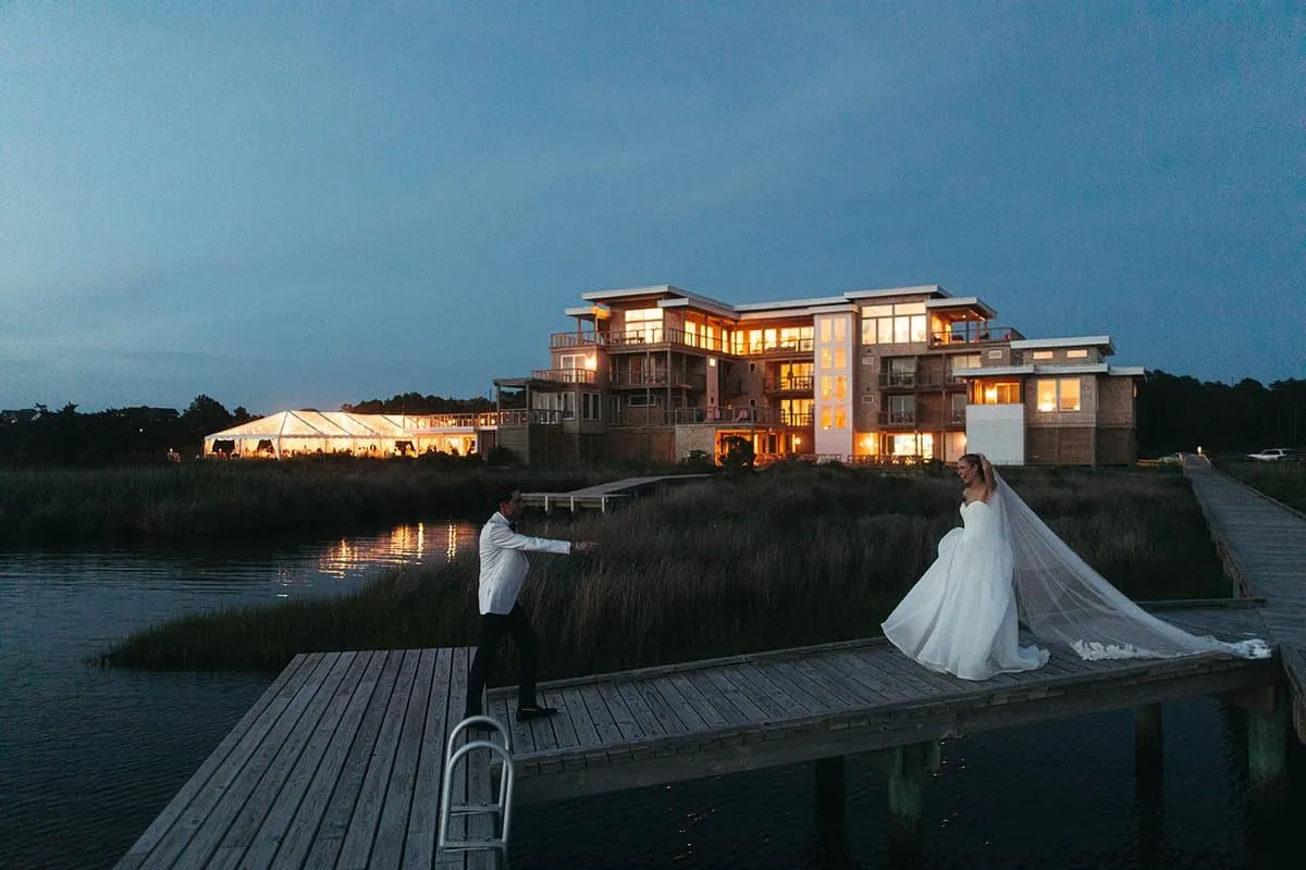 Bride on the dock at blue hour, the tent glowing behind