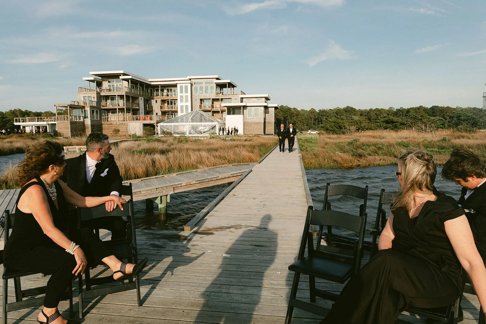 Guests seated on the dock as the grooms walk out