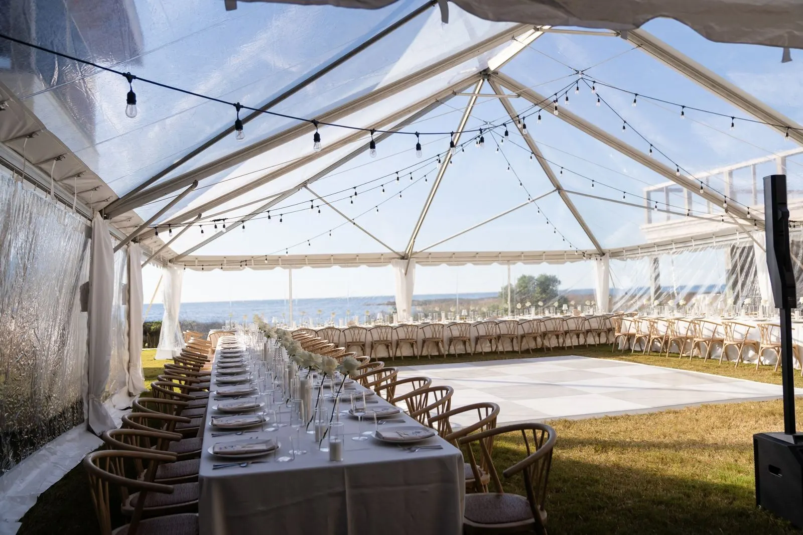 Inside the clear-top tent, tables facing the sound